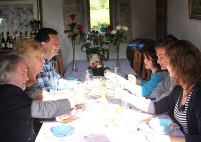 Table d'hôtes Bayeux at La Ferme Manoir Saint Barthélemy: People toasting at a dinner table.