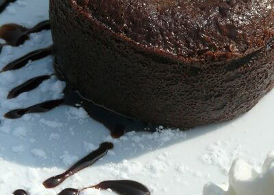 Chocolate lava cake with whipped cream and chocolate sauce, served at Table d'hôtes Bayeux.