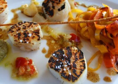 Seared scallops with colorful vegetable ribbons, part of a Table d'hôtes Bayeux meal at La Ferme Manoir Saint Barthélemy.