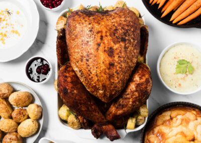 Table d'hôtes Bayeux feast: Roasted turkey surrounded by potatoes, carrots, mashed potatoes, cranberry sauce, and apple pie.