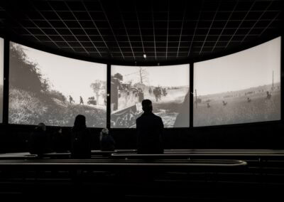 People watch a panoramic black and white film at the L'Histoire du Débarquement et de la Bataille de Normandie museum.