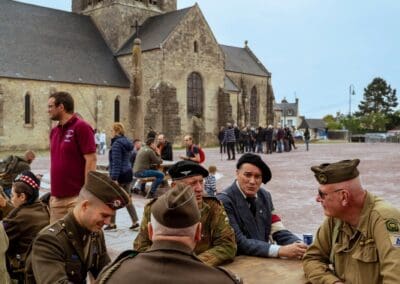 WWII reenactors gather in front of Sainte-Mère-Église church in Normandie, France. Débarquement history.