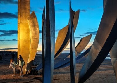 Two children at Les Braves monument on Omaha Beach, Normandie, France. L'Histoire du Débarquement et de la Bataille de Normandie.