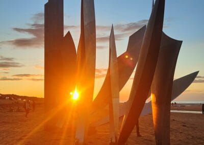Normandy beach sculpture at sunset. A poignant image related to L'Histoire du Débarquement et de la Bataille de Normandie.