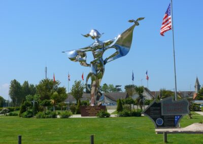 World Peace Statue near Bayeux, Normandie, with a US flag and National Guard memorial. Explore Chambres d'Hôtes in Calvados.