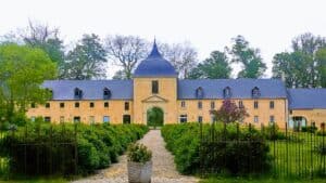 Bayeux medieval festival: yellow stone building with a blue dome and manicured gardens.